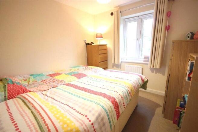 Cozy single bedroom featuring a colorful bedspr...