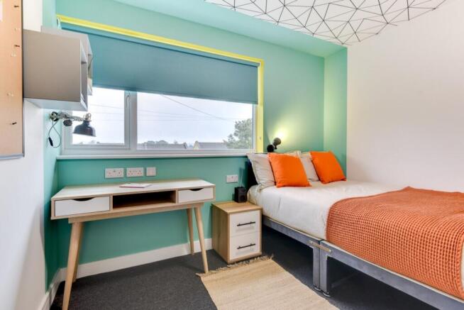 Bright modern bedroom with stylish study desk a...
