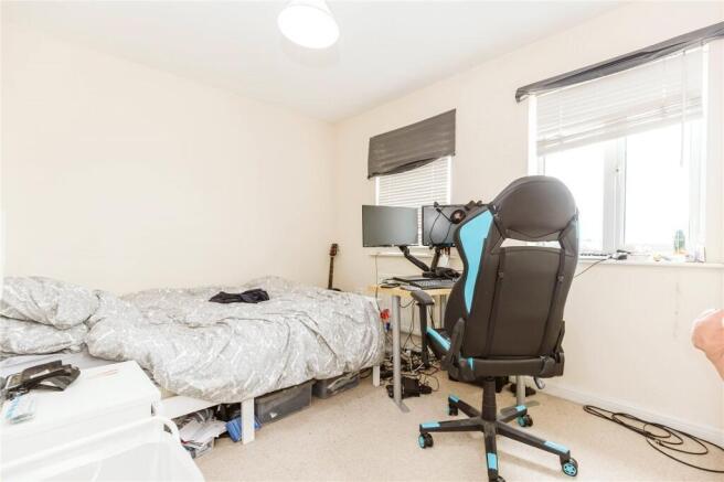 A cozy single bedroom with a comfortable bed, a...