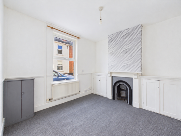 Tidied vacant room with clean carpet and cabinet