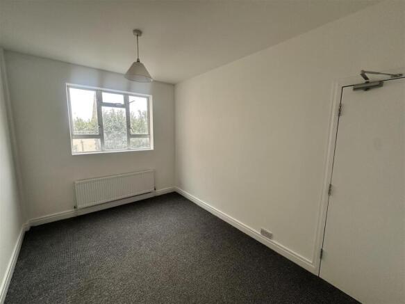 Bright simple bedroom with large window and hea...