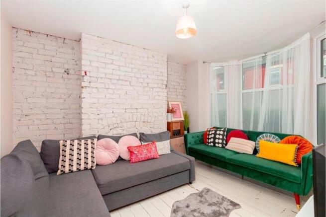 Bright living room with sofas and exposed brick...