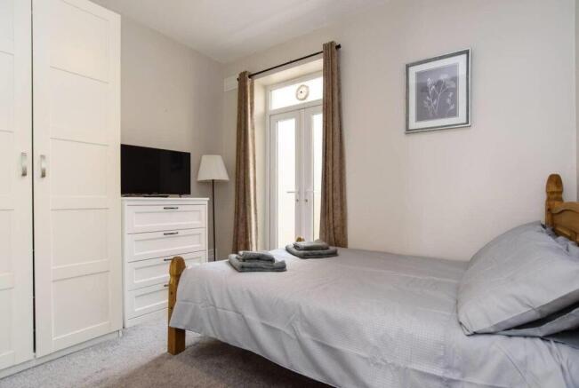 Bright bedroom with double bed and balcony acce...
