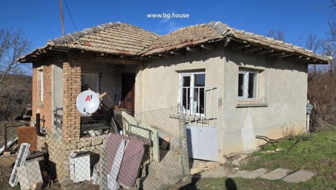 Close-up image showing the corner of a Bulgarian house with stone base and plastered walls