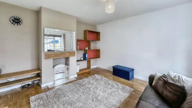 Bright lounge with wooden floors and plush rug...