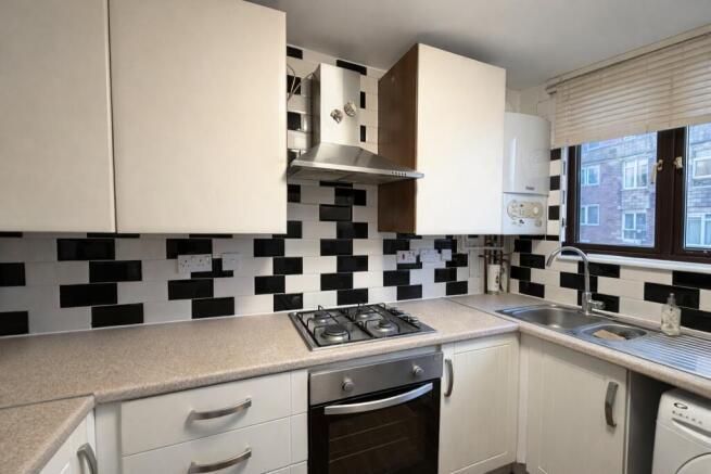 Modern galley kitchen with a stainless-steel ov...