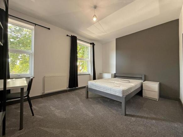 Spacious modern bedroom with bright large windo...