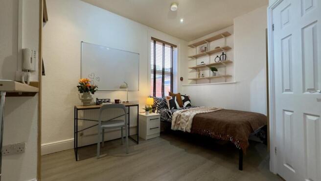 A bright and inviting double bedroom with a coz...