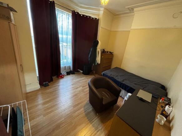Bright single bedroom with large window and tal...