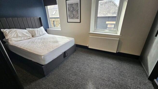 A neat and tidy bedroom featuring a large bed w...