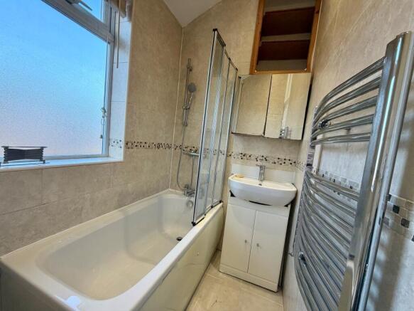 Bright, modern bathroom with a full-size bathtu...