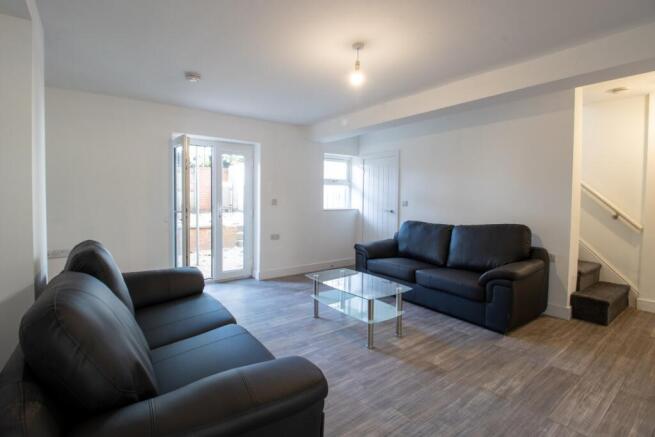 A modern, well-lit living room featuring comfor...