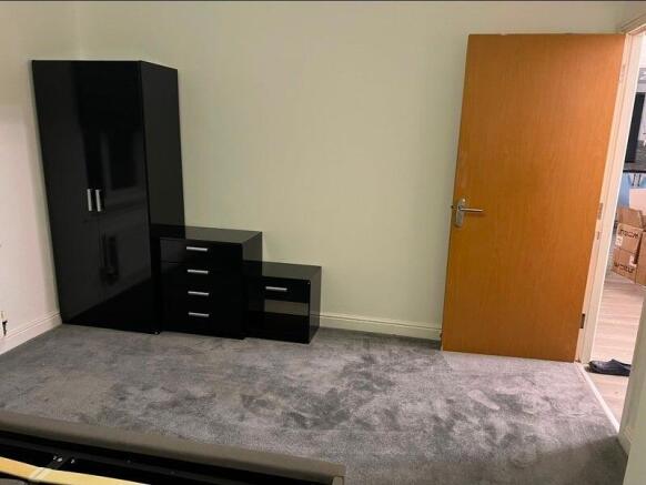 Simple furnished bedroom with neutral carpeting...