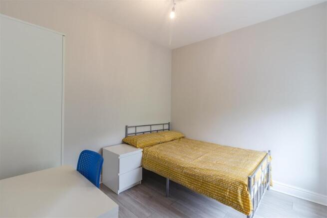 Bright bedroom with sleek wood flooring...