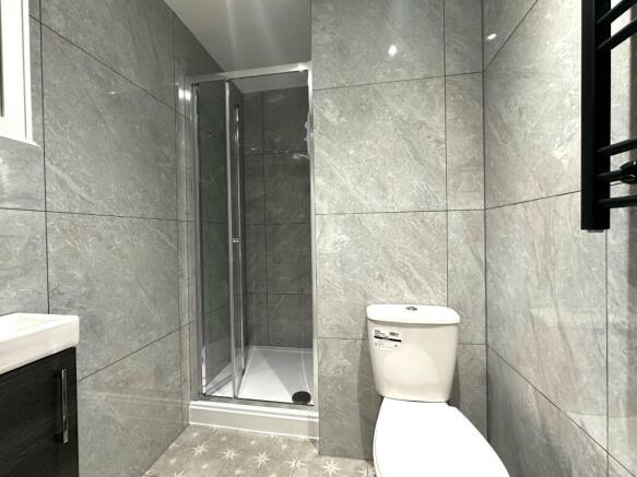 Modern tiled bathroom with a glass-enclosed sho...