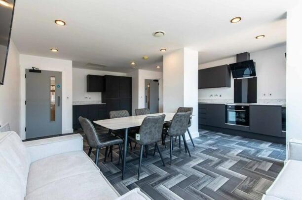 A modern kitchen and dining area with sleek bla...