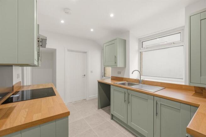 Modern kitchen with sleek sage green cabinetry...