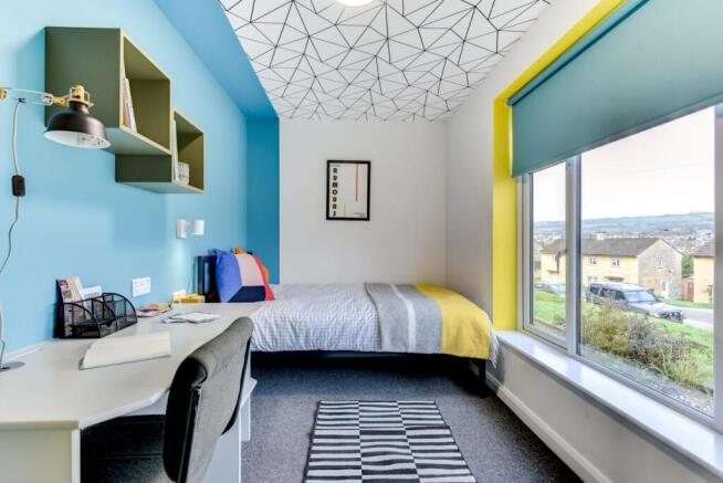 Bright, modern single bedroom with a study desk...
