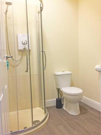 Bright, modern bathroom with a curved glass sho...