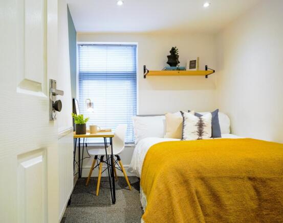 A bright and inviting double bedroom featuring ...