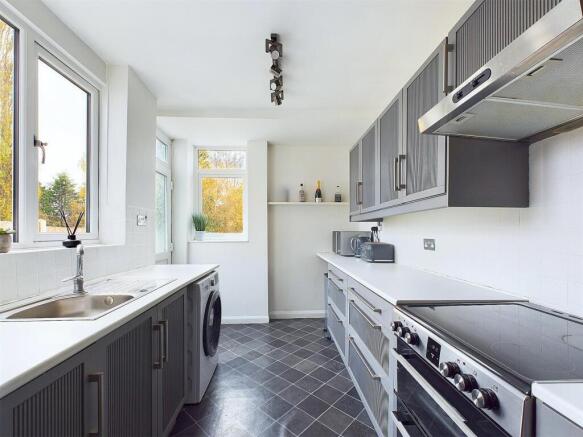 Bright modern galley kitchen with sleek grey ca...