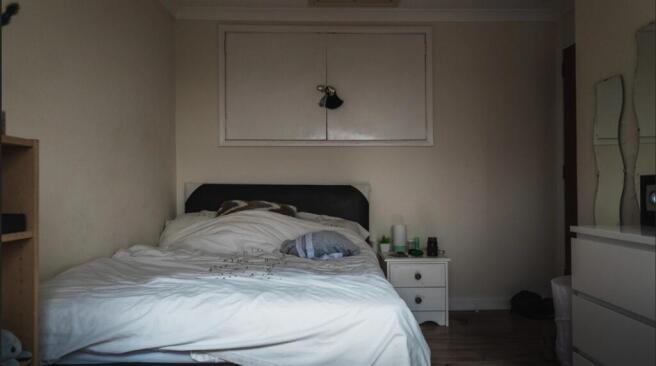 Cozy single bedroom featuring a neatly made bed...