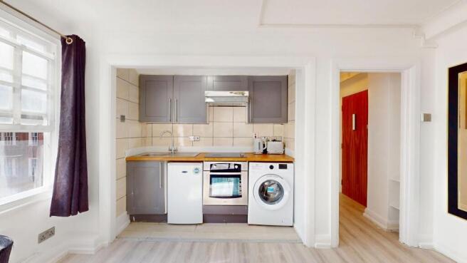 Bright compact kitchen with modern grey cabinet...