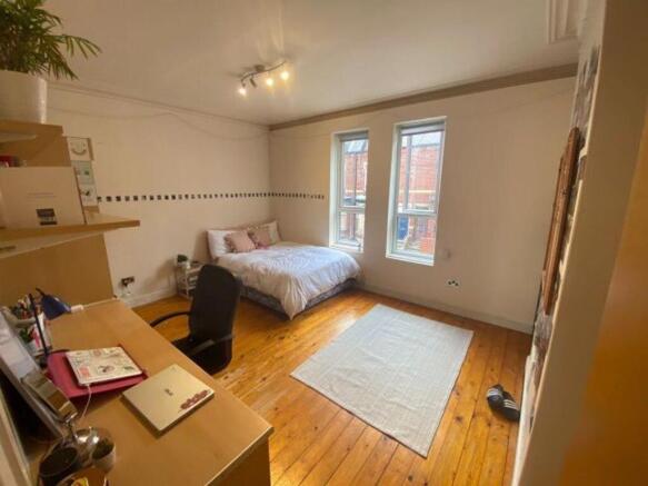 A bright and tidy bedroom featuring a spacious ...
