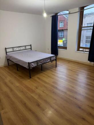 Bright, spacious bedroom with stylish wood floo...