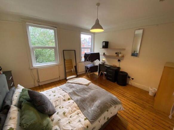 A bright and inviting master bedroom featuring ...