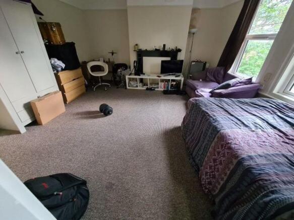 Spacious, well-lit bedroom featuring a large wi...