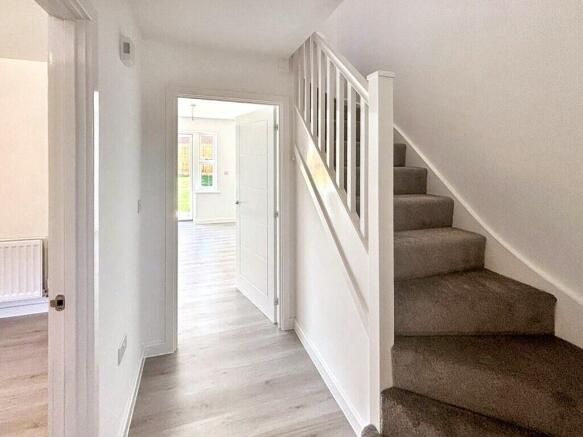 Bright, clean entrance hallway with light wood-...