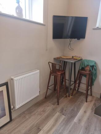 Compact breakfast nook with tall metal stools a...