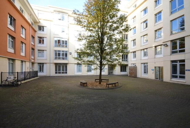 Bright courtyard with central tree and seating...