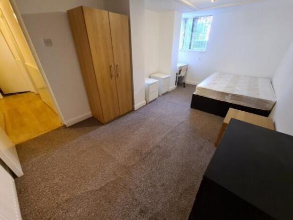 Bright, simply furnished double bedroom with a ...