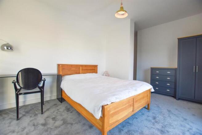 Spacious bedroom with double bed and desk area...
