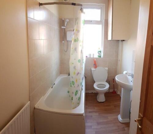 Bright, clean bathroom with a tub and overhead ...
