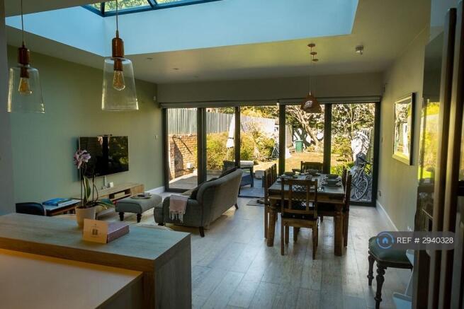 Open Lounge With Bifold Doors Open To Garden