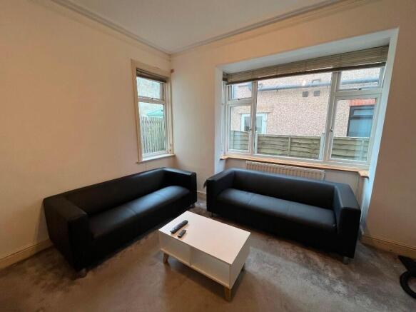 Bright, uncluttered living room with two matchi...