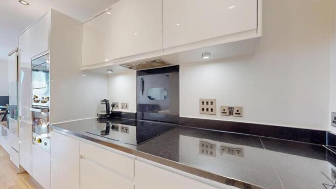 Modern high-gloss kitchen with sleek worktops...