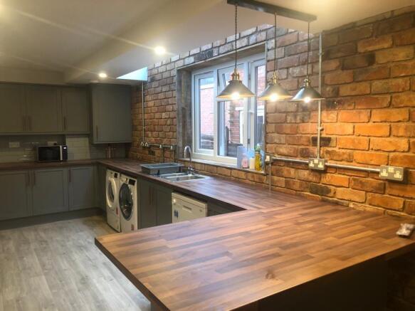 Modern kitchen with warm wood-effect countertop...