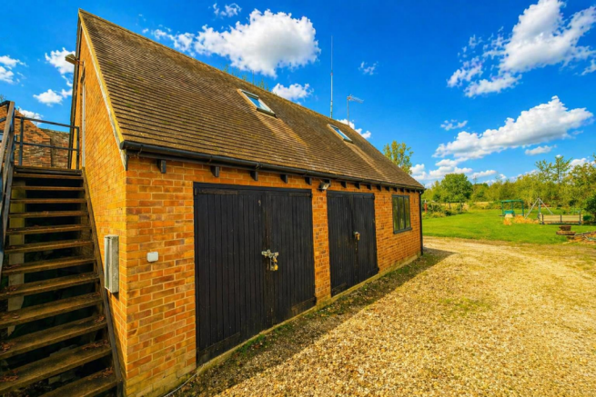 Sunny rural outbuilding and garden scene.png