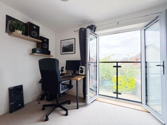 Bright, modern bedroom with a compact study are...