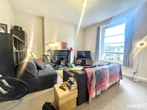 Bright lounge with feature fireplace and window...