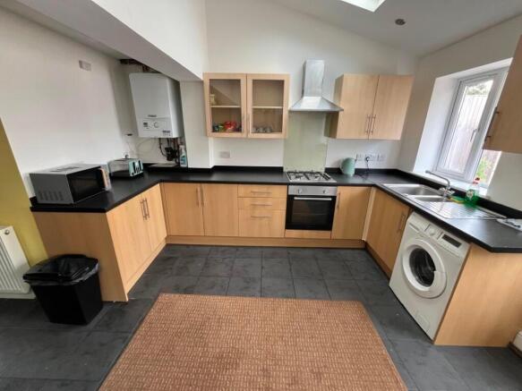 Modern fitted kitchen with light wood cabinets,...