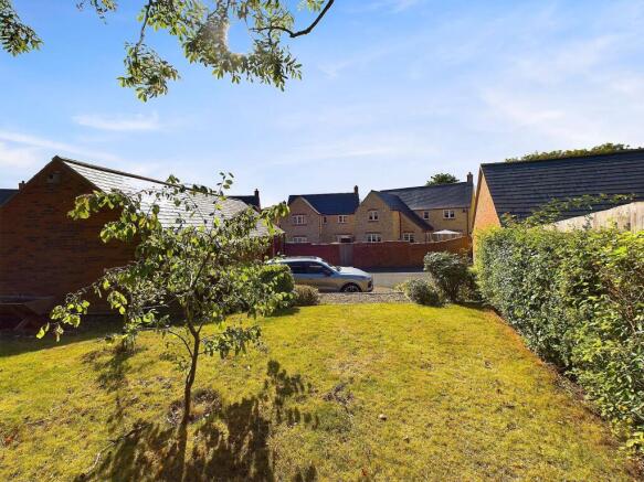 Rear garden showing full garden with double garage and driveway parking