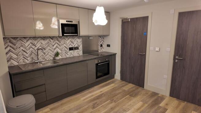 Modern fitted kitchen with grey cabinets, integ...