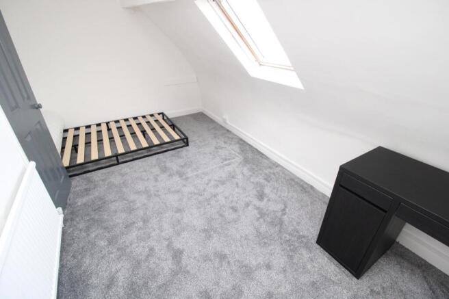 Bright attic bedroom with plush carpet and desk...