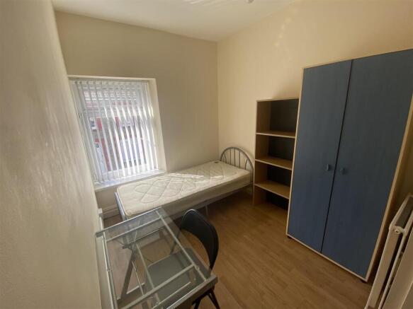 Bright bedroom with desk and ample storage spac...