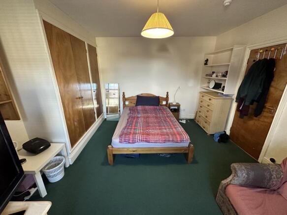 Neat bedroom with a central wooden double bed, ...